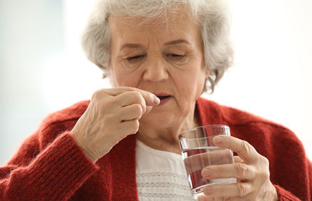 senior woman taking an oral antiviral