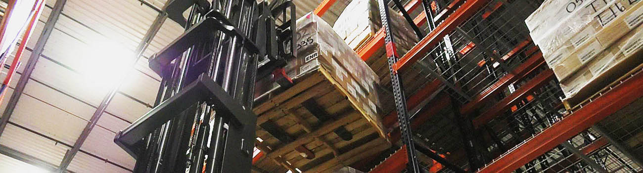 forklift raising pallet of boxes to a hight shelf in a warehouse