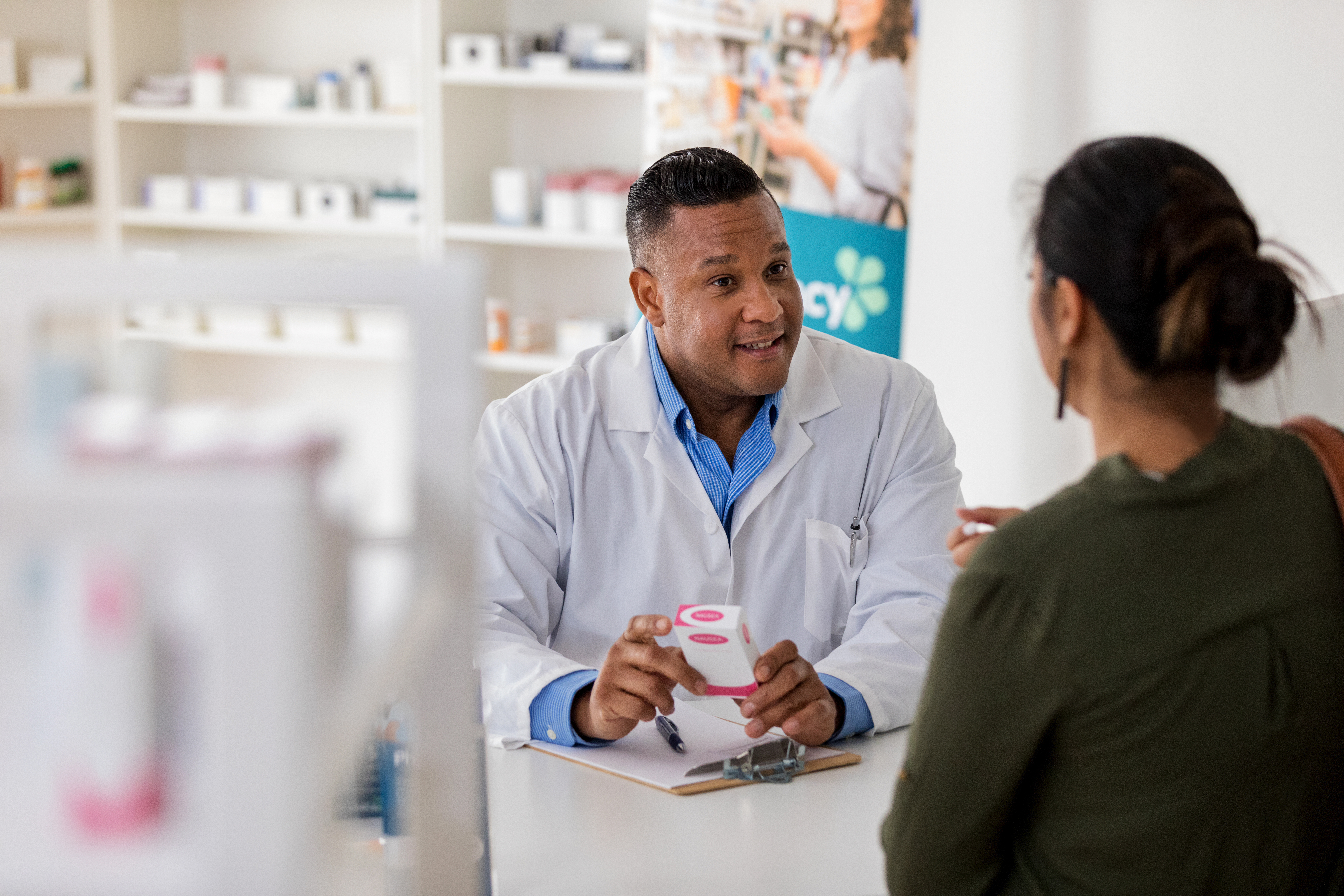Pharmacist talking to a customer about their medication.