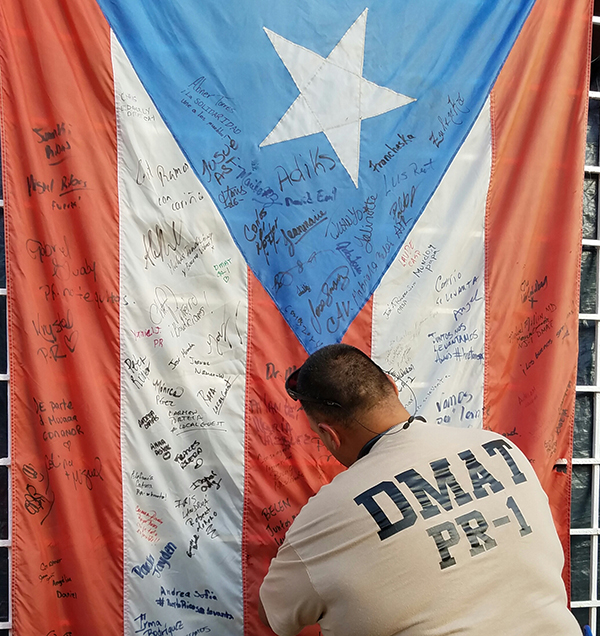 DMAT team member signs the Puerto Rico flag